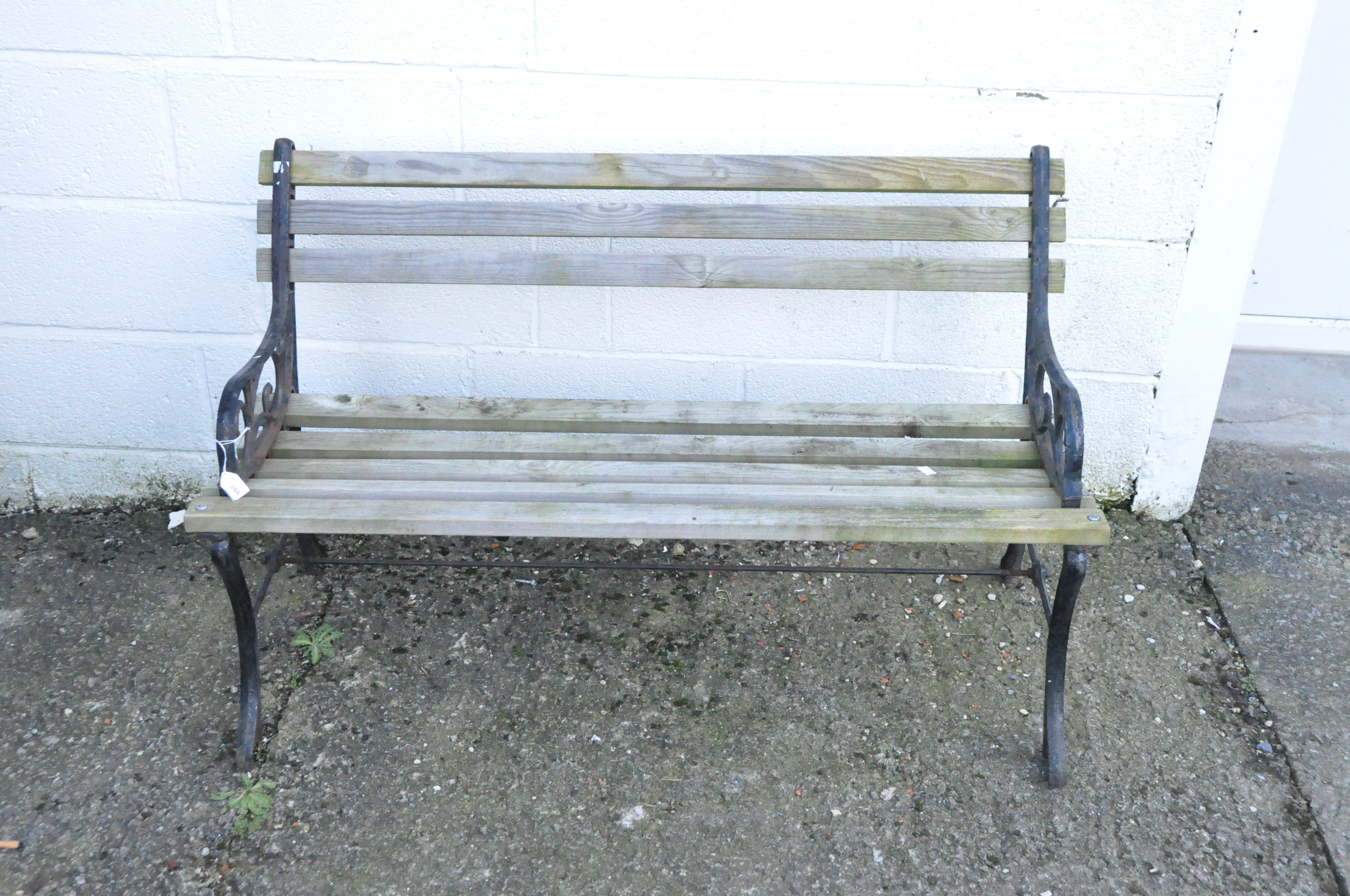 A two-seater wood garden bench with metal ends,