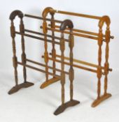 Two early 20th century wooden free standing towel rails. Each approximately 62cm x 76cm.