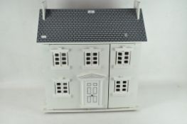 A contemporary painted wooden dolls house with Plan Toys furniture and fittings,