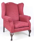 A Georgian style upholstered wing back armchair, 20th century,