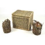 A wicker basket and two flagons in wicker cases