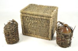 A wicker basket and two flagons in wicker cases