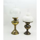 Two early 20th century oil lamps with glass shades and funnels,