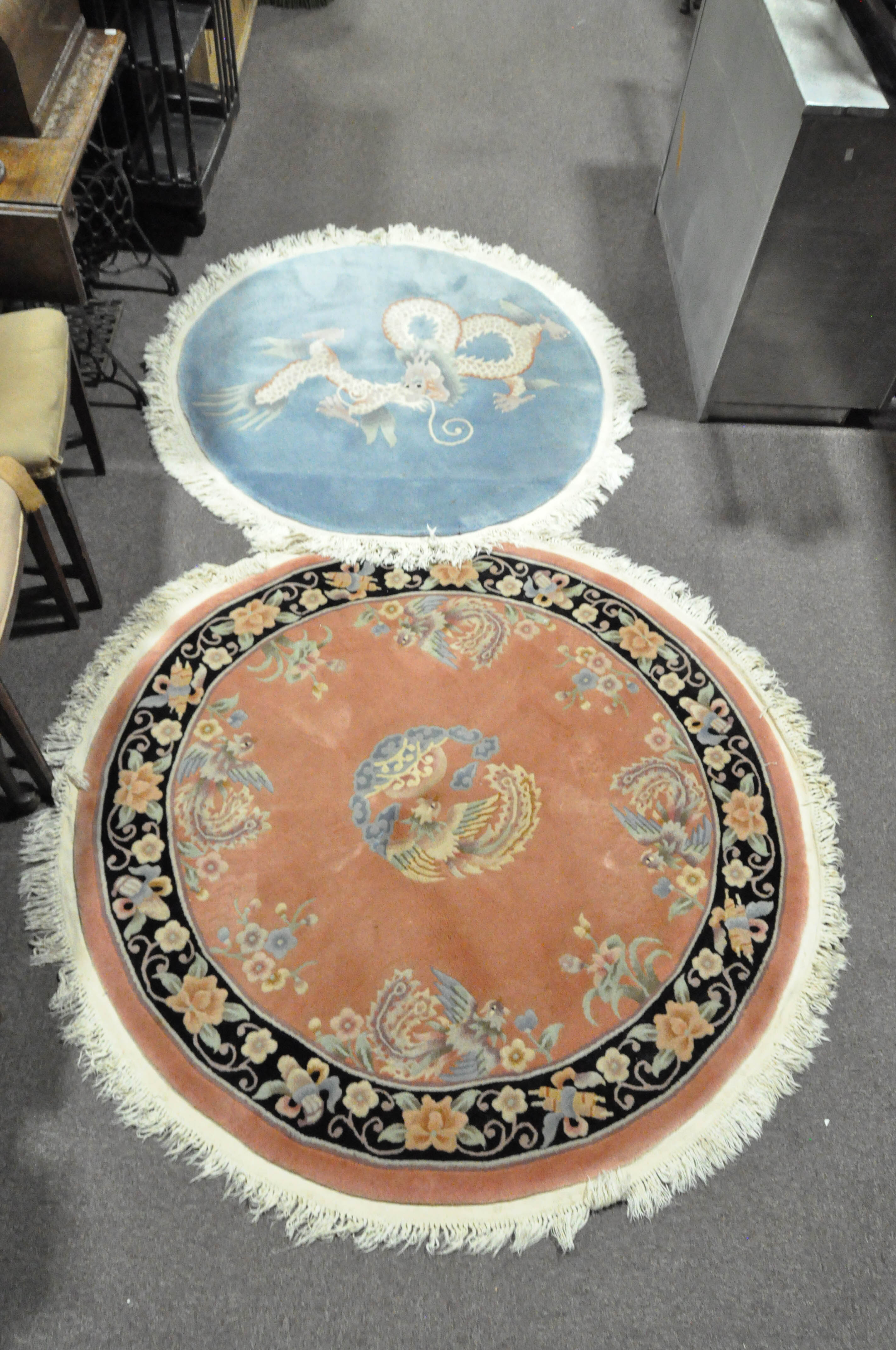 Two modern Chinese circular rugs, one featuring a dragon on a pale blue ground,