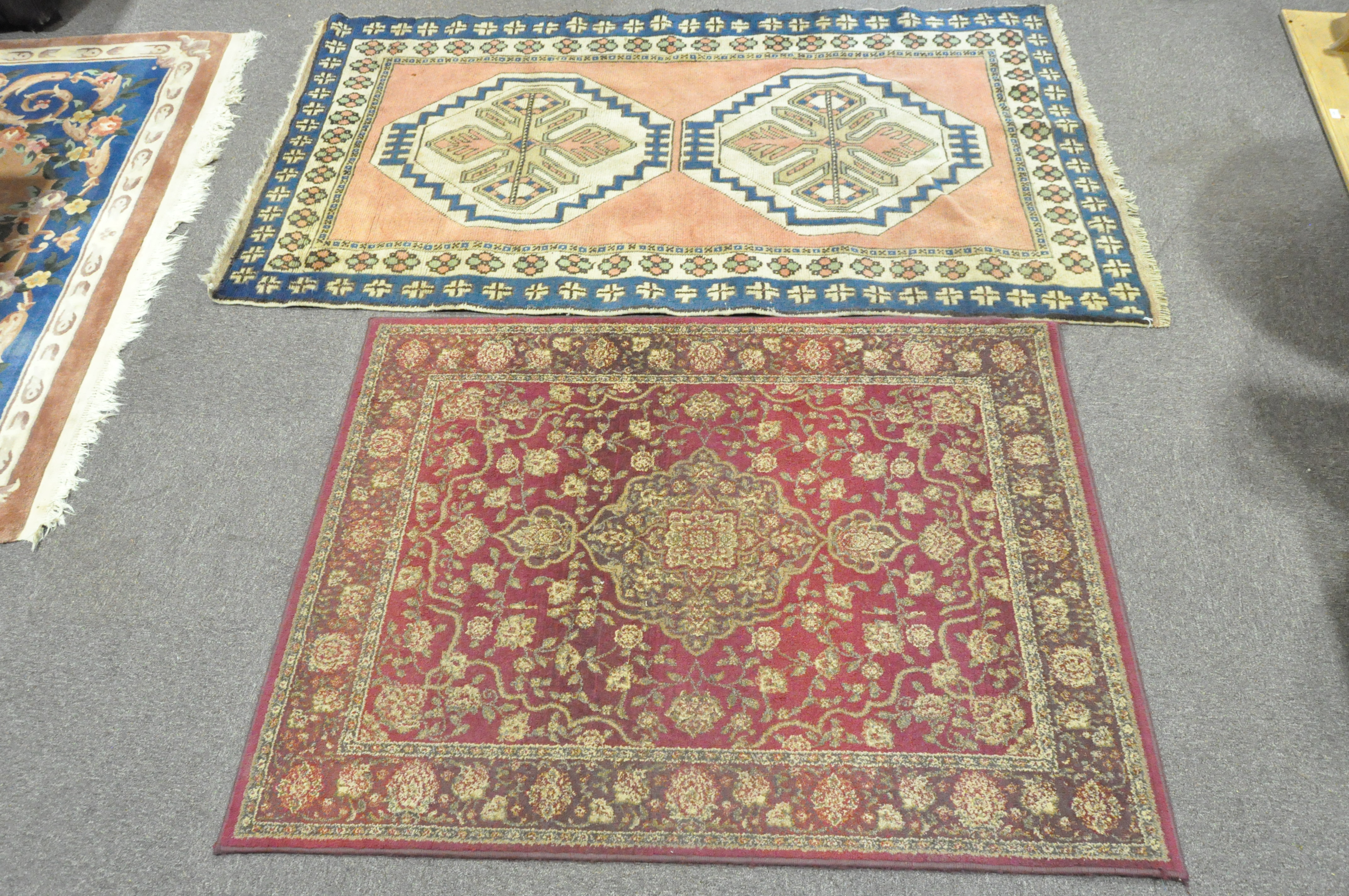 Two rugs, one a contemporary red ground rug,