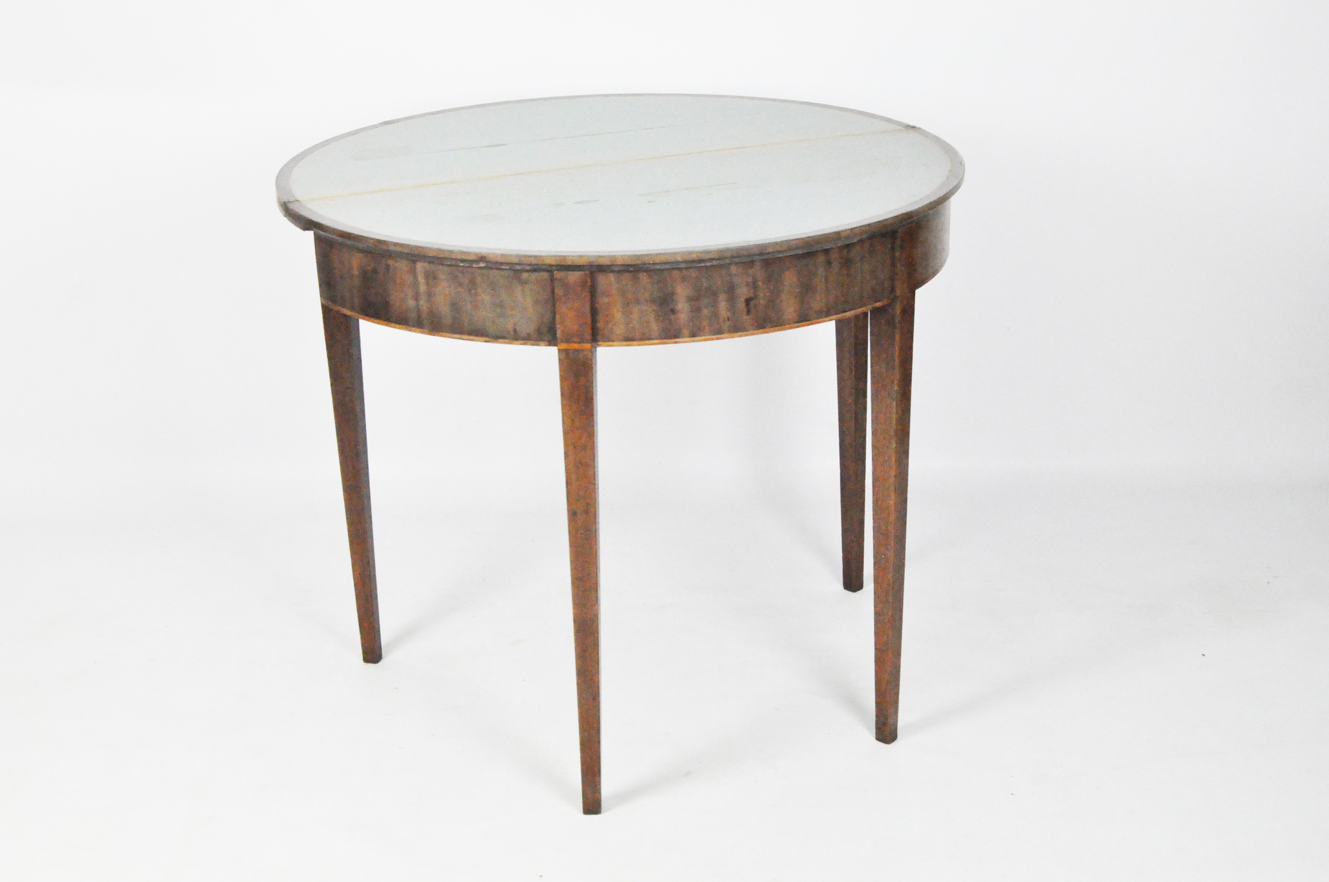 An early 19th century mahogany demi-lune table with cross banded top,