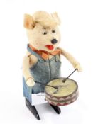 A Schuco clockwork toy in the form of a pig playing a drum, circa 1930s, height 11cm,