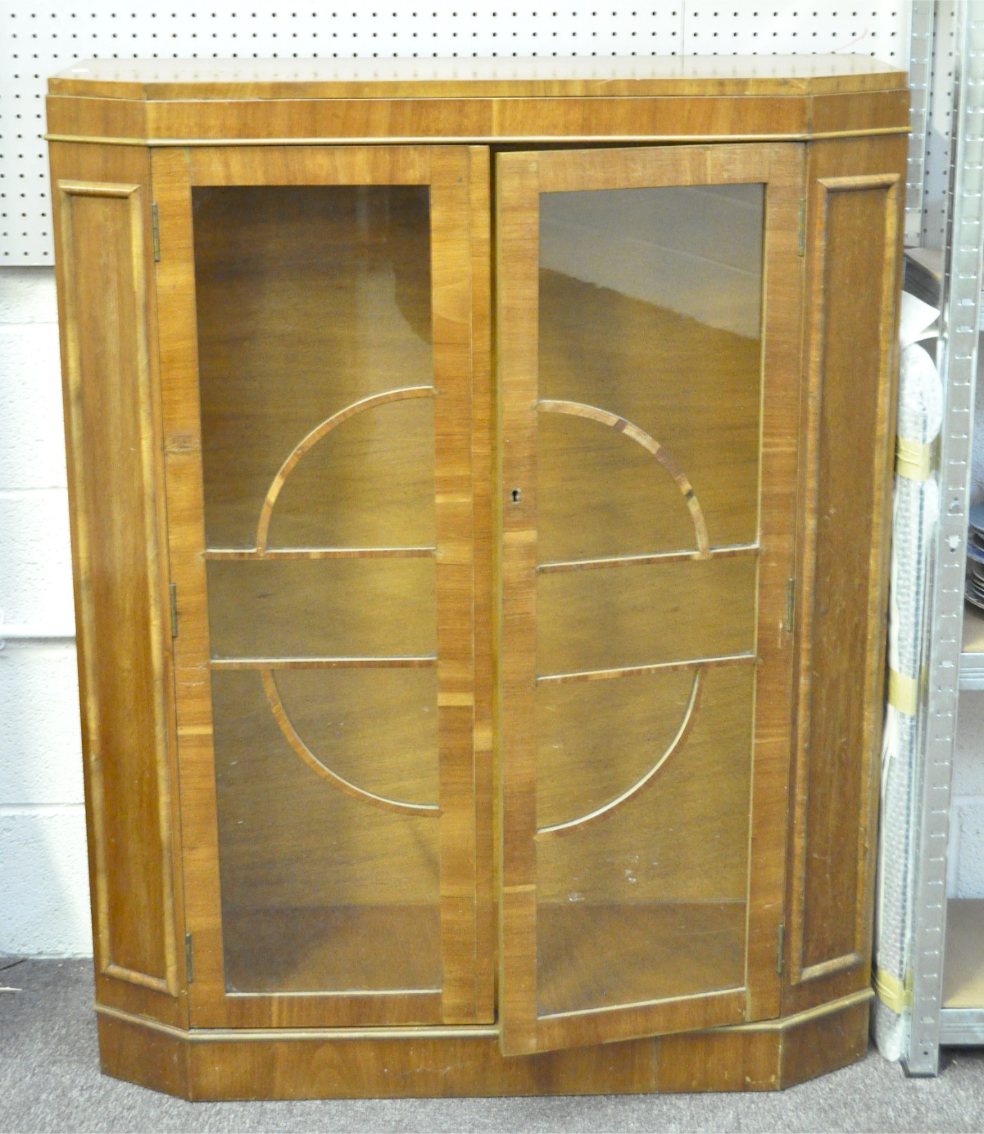 An Art deco display cabinet, the vaneered case with glazed doors and side panels,