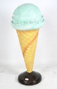 A large advertising shop display model of an ice cream, the waffle cone with mint coloured scoop,