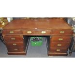 A contemporary large wooden campaign desk inset with brown leather top,