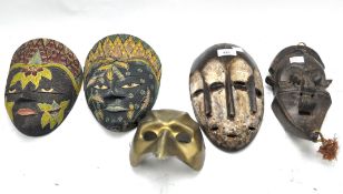 Five assorted masks, including two African tribal masks and others,