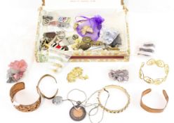 A collection of costume jewellery, including copper bangles, enamel badges, earrings,