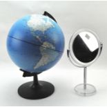 A contemporary magnifying bathroom mirror and a globe on a stand,