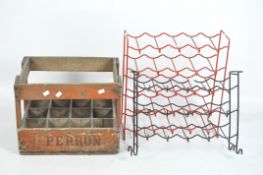 A vintage wooden bottle crate and two metal wine racks,