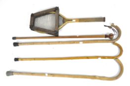 A collection of vintage walking sticks and tennis racquet,