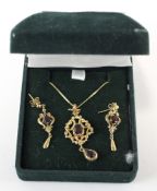 A set of 9ct gold and garnet earrings and pendant, modelled as motifs with central stones,