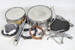 A collection of instruments and music equipment, including a pearl snare drum, tambourine,