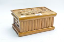 A contemporary carved wooden box, the hinged lid decorated with floral motifs