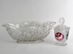 A clear and red moulded glass lidded biscuit jar and a dish,