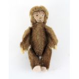 A 1930s/1940s miniature Schuco monkey, mohair body, painted tin-plate face,