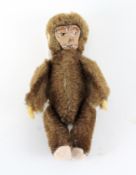 A 1930s/1940s miniature Schuco monkey, mohair body, painted tin-plate face,