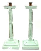 A pair of 20th century green painted candlesticks, in the gothic style,