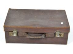 A vintage mid-century brown leather suitcase,