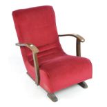 An Art Deco sprung rocking chair with red velvet upholstery,