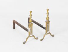 A pair of early 20th century fire dogs, with brass baluster finials and claw feet,
