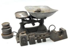 An early set of cast iron kitchen scales with a quantity of related weights,