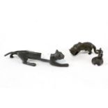 A group of three metal items, two being in the form of cats,