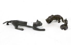 A group of three metal items, two being in the form of cats,