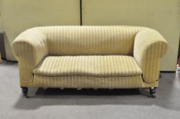 A Victorian two seater green striped sofa on turned supports.