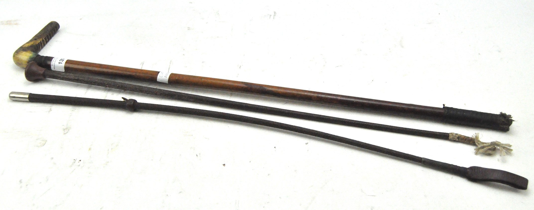 Three leather riding crops, one with horn handle,