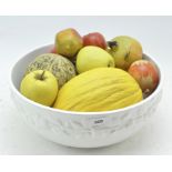 A white glazed ceramic bowl of artificial wood and ceramic fruit,