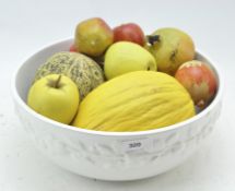 A white glazed ceramic bowl of artificial wood and ceramic fruit,