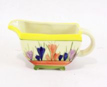 A Clarice Cliff style jug, handpainted with flowers on a yellow ground, marked to the base,