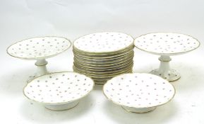 A vintage part dinner service decorated with small rose buds between gilt rims,