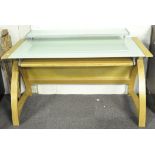 A contemporary desk, the wooden frame featuring a pull out drawer and curved supports,