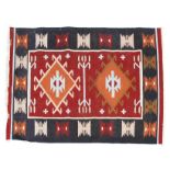 A Kilim wool rug, 20th century woven with geometric forms and lozenges within red and blue borders,