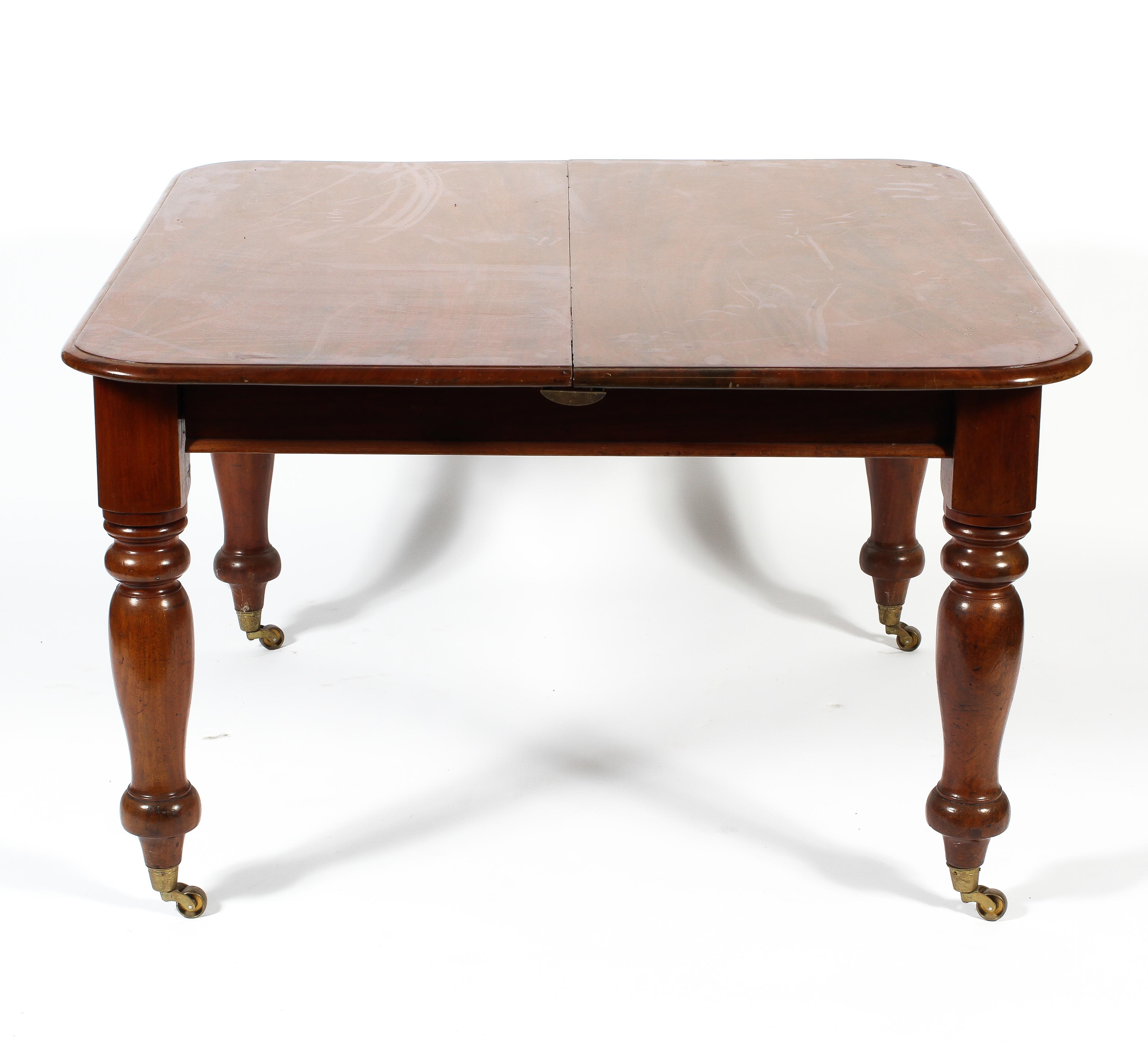 A Victorian mahogany extending dining table, with one additonal leaf,