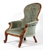 A Victorian mahogany framed button back upholstered armchair, with scroll carved arms,