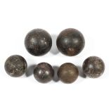 A collection of antique cannon balls in graduated sizes, comprising:two larger examples,