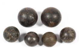 A collection of antique cannon balls in graduated sizes, comprising:two larger examples,