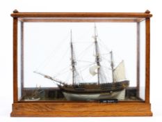 An oak and glass cased scratch built model of HMS Bounty, in a naturalistic setting,.