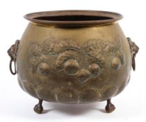 A brass jardiniere with lion hoop handles raised on three ball and claw feet,