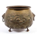 A brass jardiniere with lion hoop handles raised on three ball and claw feet,