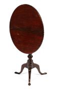 A Geogian mahogany flip top tripod table with birdcage locking mechanism and detailed edge,