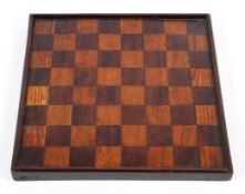A 19th century treen chess board, with chequerboard veneers within mahogany frame,