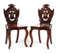 A pair of early 19th century mahogany hall chairs,